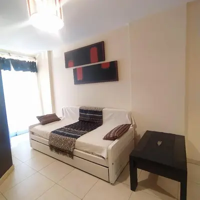 a small bedroom with a bed and a table at Departamento zona Nuevocentro Shopping in Cordoba
