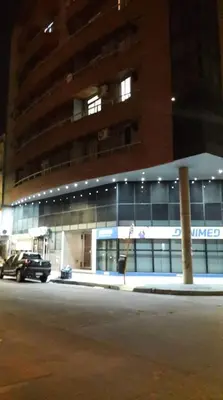 a car parked in front of a building at night at Departamento zona Nuevocentro Shopping in Cordoba