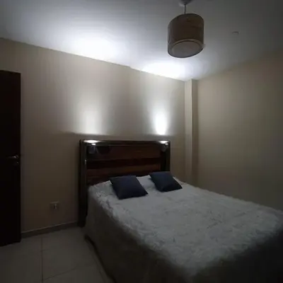 a bedroom with a bed with two blue pillows at Departamento zona Nuevocentro Shopping in Cordoba