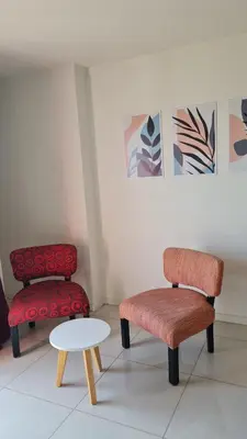 two chairs and a stool and a table in a room at Confort Río Cuarto I in Río Cuarto