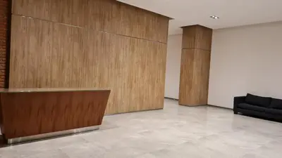 a lobby with a wooden wall and a couch at Confort Río Cuarto I in Río Cuarto