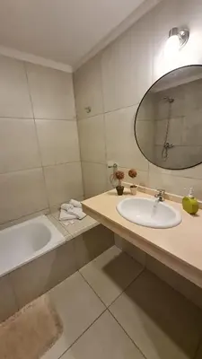 a bathroom with a sink and a tub and a mirror at Confort Río Cuarto I in Río Cuarto