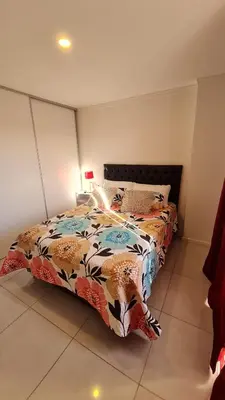 a bedroom with a bed with a colorful comforter at Confort Río Cuarto I in Río Cuarto