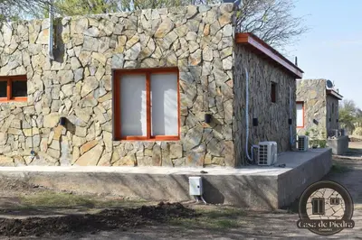 a stone building with a window and a stone wall at Cabañas Casa de Piedra Los Molles - San Luis in Los Molles