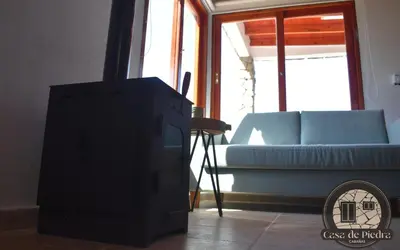 a living room with a tv and a couch at Cabañas Casa de Piedra Los Molles - San Luis in Los Molles