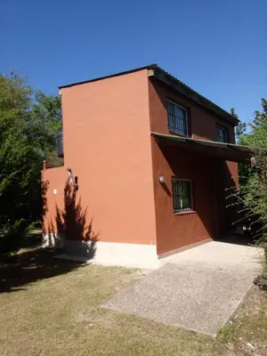 a brown building with a tree in front of it at Lo de Juan Cabañas in Los Reartes