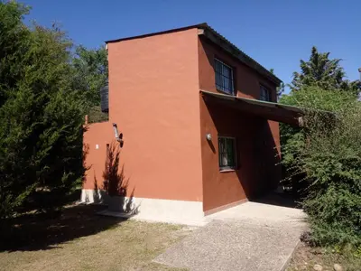 a brown building with a window on the side of it at Lo de Juan Cabañas in Los Reartes