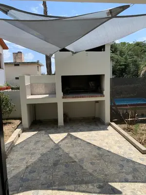 a white outdoor fireplace with awning on a patio at Casa de Ali in Villa Carlos Paz