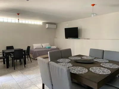 a living room with a dining table and a bedroom at Casa de Ali in Villa Carlos Paz