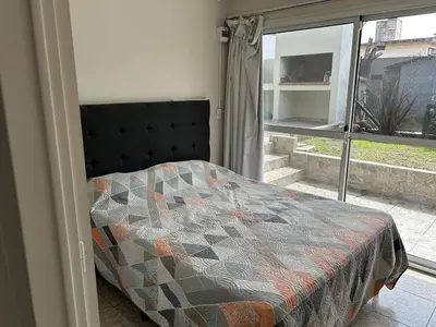 a bedroom with a quilt on a bed and a window at Casa de Ali in Villa Carlos Paz
