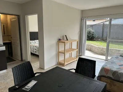 a living room with a table and chairs and a bed at Casa de Ali in Villa Carlos Paz