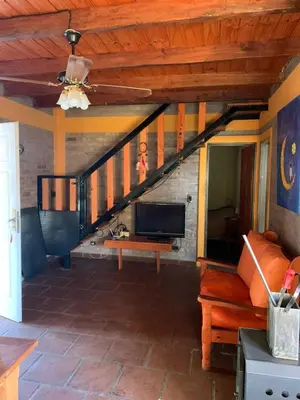 a living room with a staircase with a couch and a tv at Malenka in Pantanillo