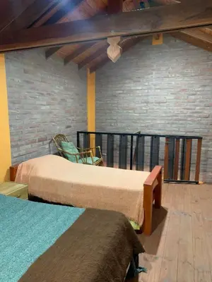 two beds in a room with a brick wall at Malenka in Pantanillo