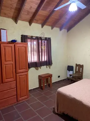 a bedroom with a bed and a dresser and a window at Malenka in Pantanillo