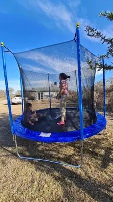 two children are playing on a trampoline at Aromas serranos in Villa Rumipal