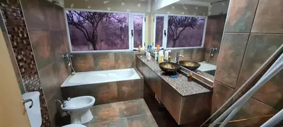 a bathroom with a tub and a toilet and a window at Aromas serranos in Villa Rumipal