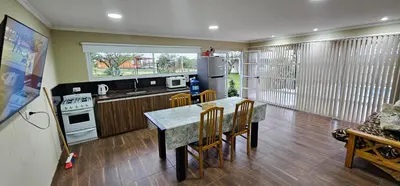 a kitchen with a table and chairs and a refrigerator at Aromas serranos in Villa Rumipal