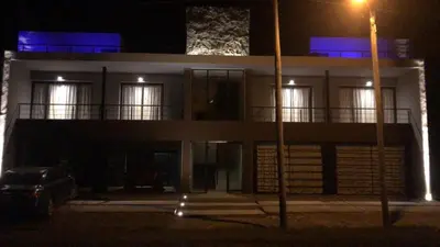 a building at night with a car parked in front at Dinastie Country in Villa Rumipal