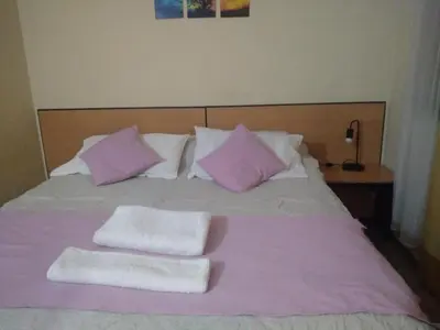 a pink and white bed with two towels on it at Departamento en Nueva Córdoba in Cordoba