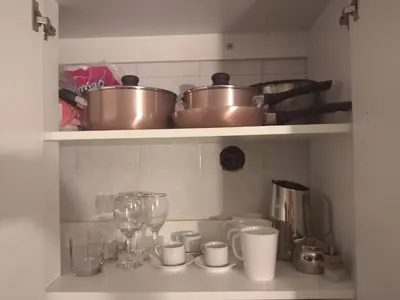 a kitchen shelf with pots and pans and cups at Departamento en Nueva Córdoba in Cordoba