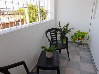 a chair and a table with plants on a balcony at CELESTINA in Cordoba