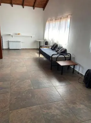 a bedroom with a bed and a bench and a window at Casa con vista a las sierras de Cordoba in Malagueño