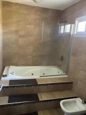 a bathroom with a bath tub and a toilet at Casa con vista a las sierras de Cordoba in Malagueño