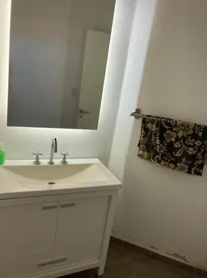 a white bathroom with a sink and a mirror at Casa con vista a las sierras de Cordoba in Malagueño