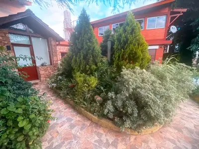 a garden in front of a house with trees and bushes at Ashram Asociación Argentina de Yoga in Mina Clavero