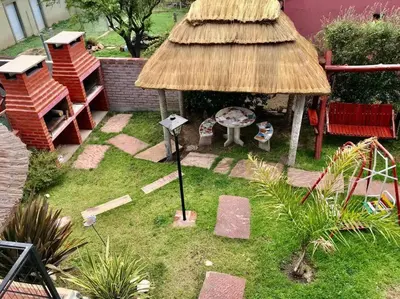a small garden with a grass roof and a table and bench at LA MILAGROS PIQUITO DE ORO in Merlo
