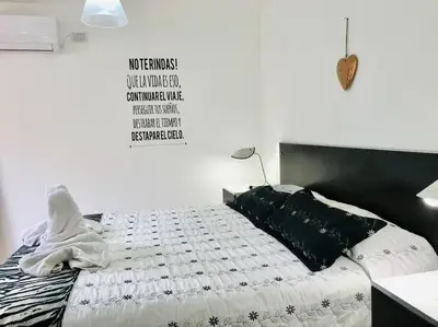 a bedroom with a bed with a black and white comforter at LA MILAGROS PIQUITO DE ORO in Merlo