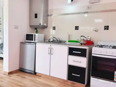 a kitchen with white cabinets and a stove at LA MILAGROS PIQUITO DE ORO in Merlo
