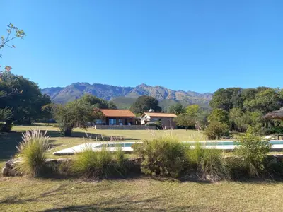 a house with a pool and mountains in the background at Posada del Paraíso-Exclusivo adultos in Las Rabonas