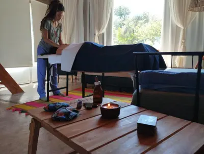 a woman sitting on a bed in a living room at Posada del Paraíso-Exclusivo adultos in Las Rabonas