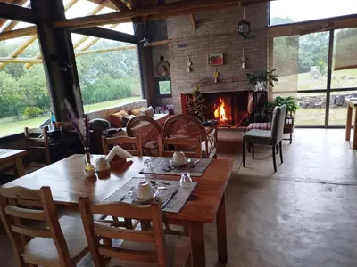 a dining room with a table and a fireplace at Posada del Paraíso-Exclusivo adultos in Las Rabonas