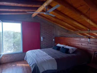 a bedroom with a large bed with a ceiling fan at Posada del Paraíso-Exclusivo adultos in Las Rabonas