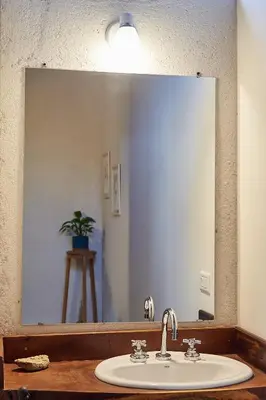 a bathroom with a sink and a large mirror at Posada del Paraíso-Exclusivo adultos in Las Rabonas