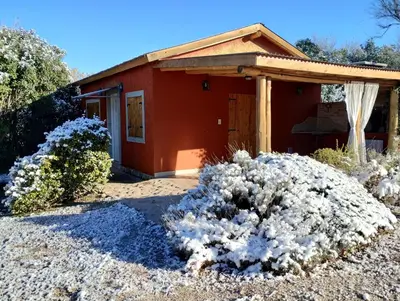a small red house with bushes in front of it at Cabañas Paraje Noviembre in Nono