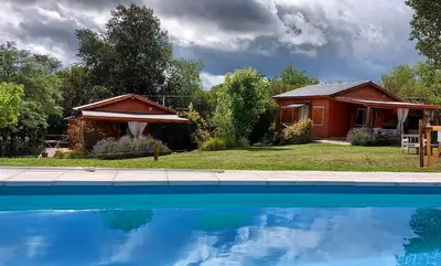 a house and a swimming pool in front of a house at Cabañas Paraje Noviembre in Nono