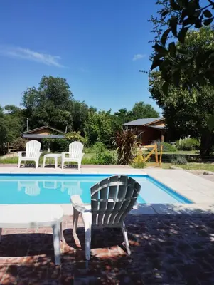 a chair sitting next to a swimming pool at Cabañas Paraje Noviembre in Nono