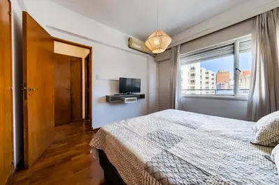 a bedroom with a bed and a tv and a window at Entre Ríos 73 - B Centro in Cordoba
