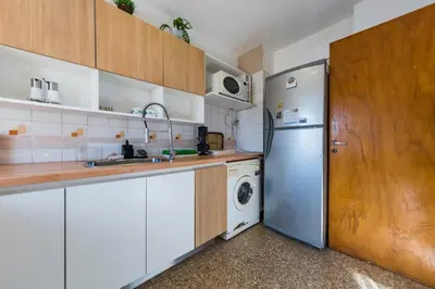 a kitchen with a refrigerator and a washer and dryer at Entre Ríos 73 - B Centro in Cordoba