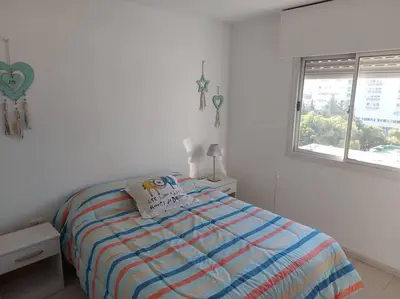 a white bedroom with a bed and a window at Departamento nuevo en Cordoba in Cordoba