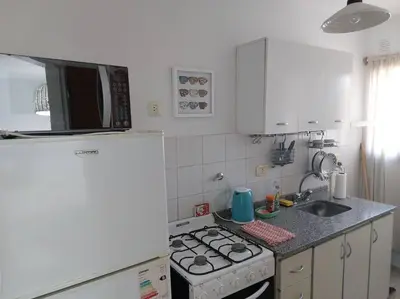 a kitchen with a stove and a white refrigerator at Departamento nuevo en Cordoba in Cordoba