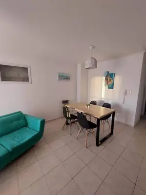 a living room with a green couch and a table at Departamento nuevo en Cordoba in Cordoba