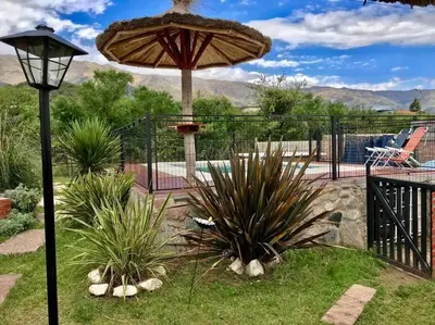 a patio with a table and an umbrella and some plants at LA MILAGROS ZORZAL COLORADO in Merlo