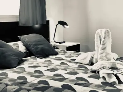 a bedroom with a bed with black and white sheets and a lamp at LA MILAGROS ZORZAL COLORADO in Merlo