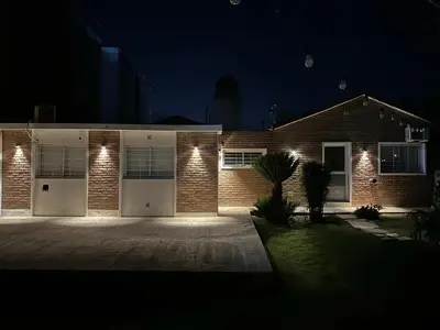 a brick house with two garage doors at night at Departamento W R T 1 in Villa Carlos Paz