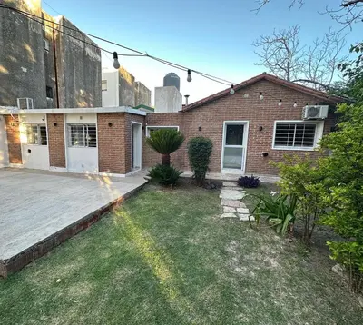 a brick house with a yard in front of it at Departamento W R T 1 in Villa Carlos Paz