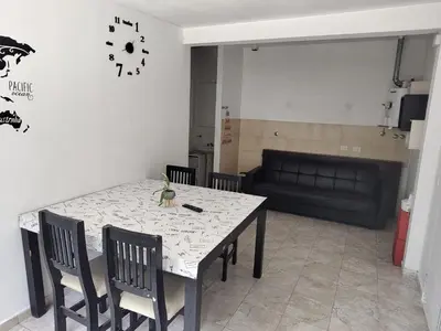 a dining room with a table and chairs and a couch at Departamento W R T 1 in Villa Carlos Paz